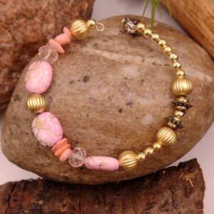 Różowo-złota bransoletka na drucie pamięciowym z nieregularnymi koralami, białymi fasetowanymi koralikami i złotymi detalami, biżuteria handmade