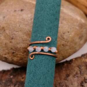 Delikatny miedziany pierścionek z czterema naturalnymi opalami o niebieskiej poświacie, regulowany, ręcznie wykonany.