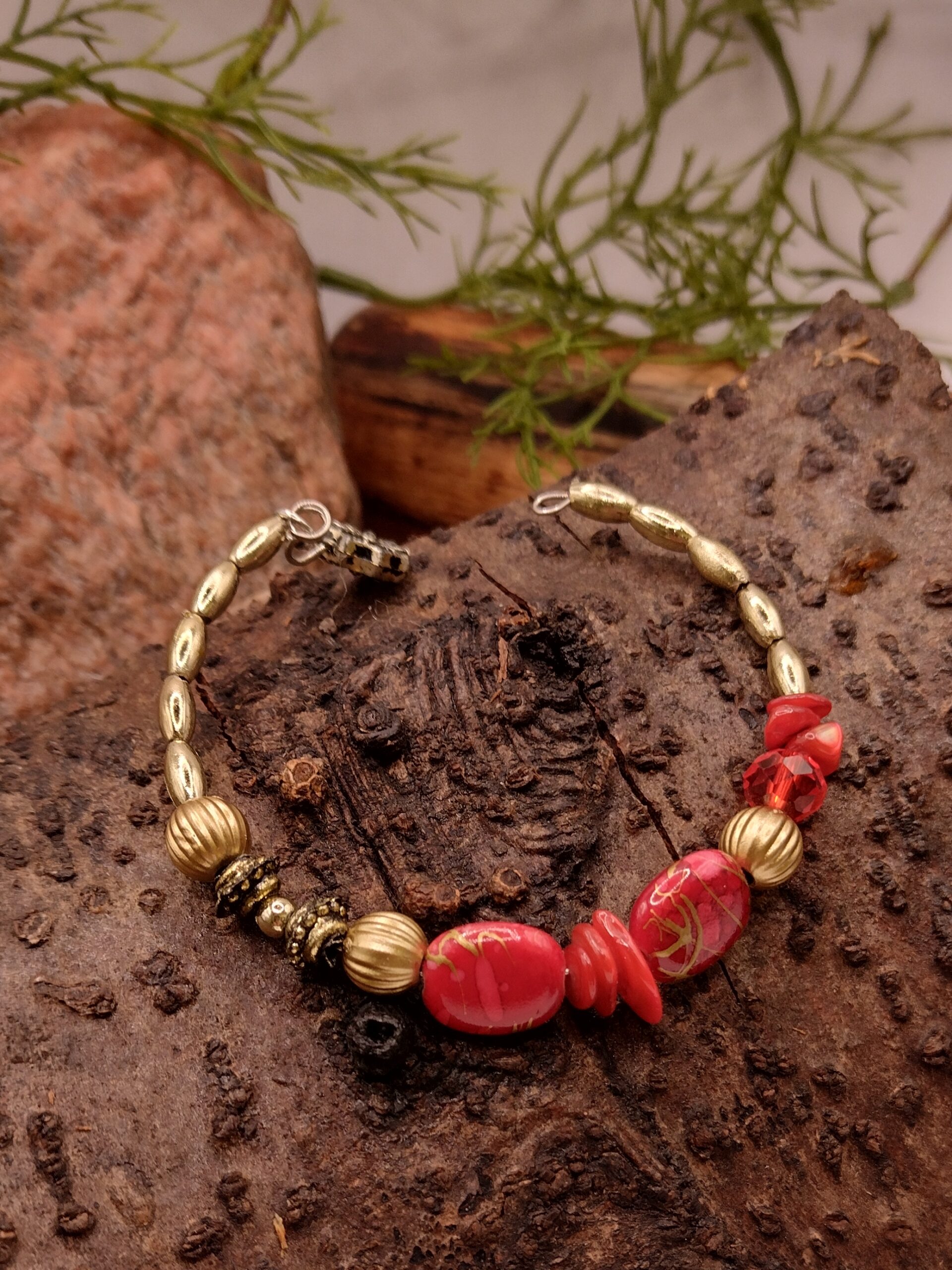 Czerwona bransoletka na drucie pamięciowym z dekoracyjnymi koralikami i złotymi przekładkami, biżuteria handmade