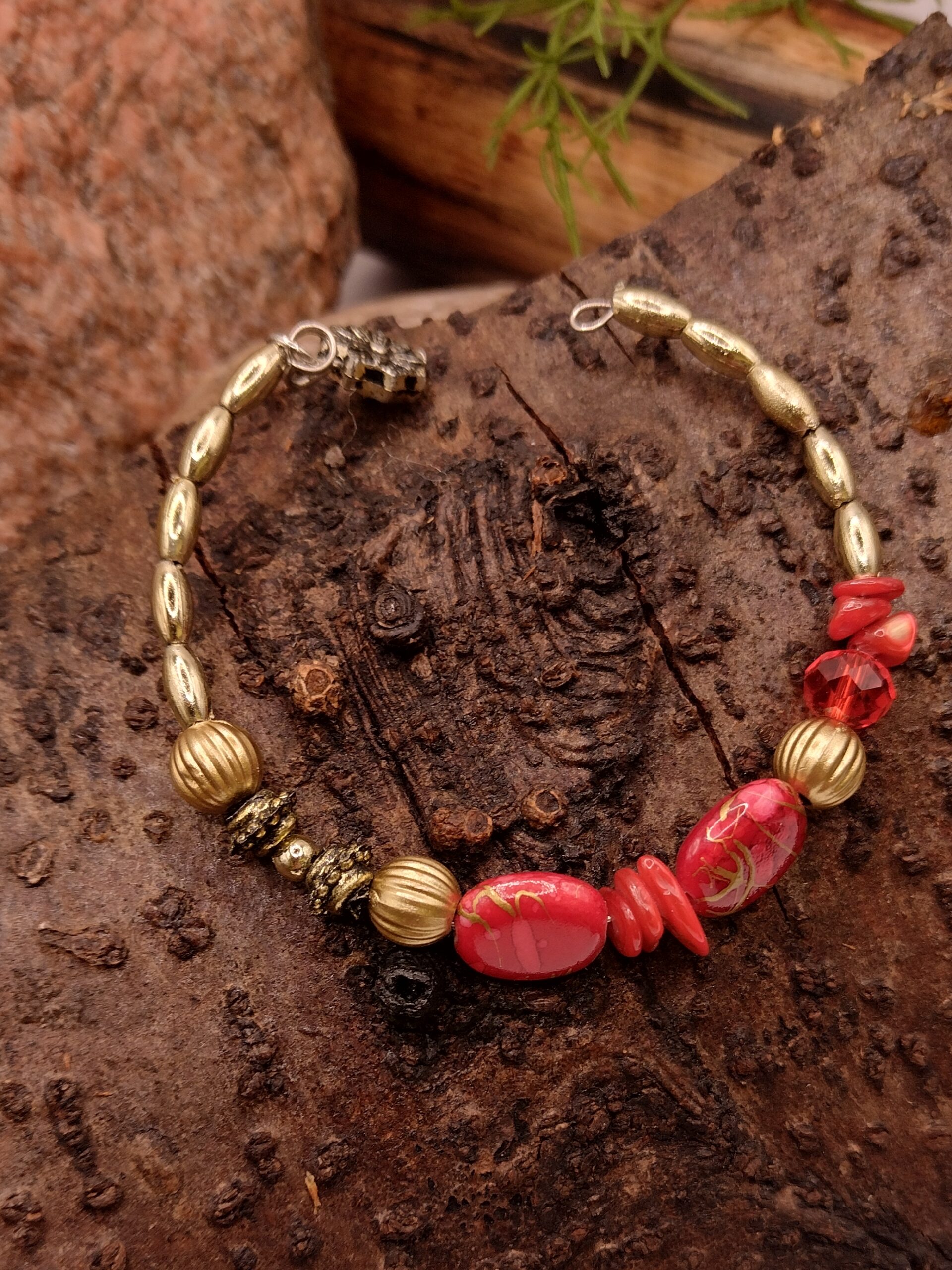 Czerwona bransoletka na drucie pamięciowym z dekoracyjnymi koralikami i złotymi przekładkami, biżuteria handmade