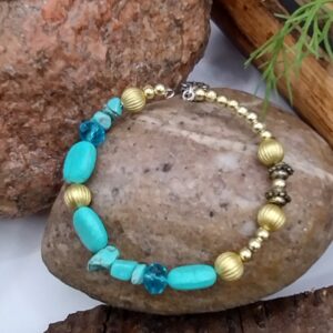 Niebieska bransoletka na drucie pamięciowym z dekoracyjnymi koralikami i złotymi przekładkami, biżuteria handmade