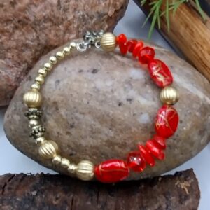 Czerwona bransoletka na drucie pamięciowym z dekoracyjnymi koralikami i złotymi przekładkami, biżuteria handmade