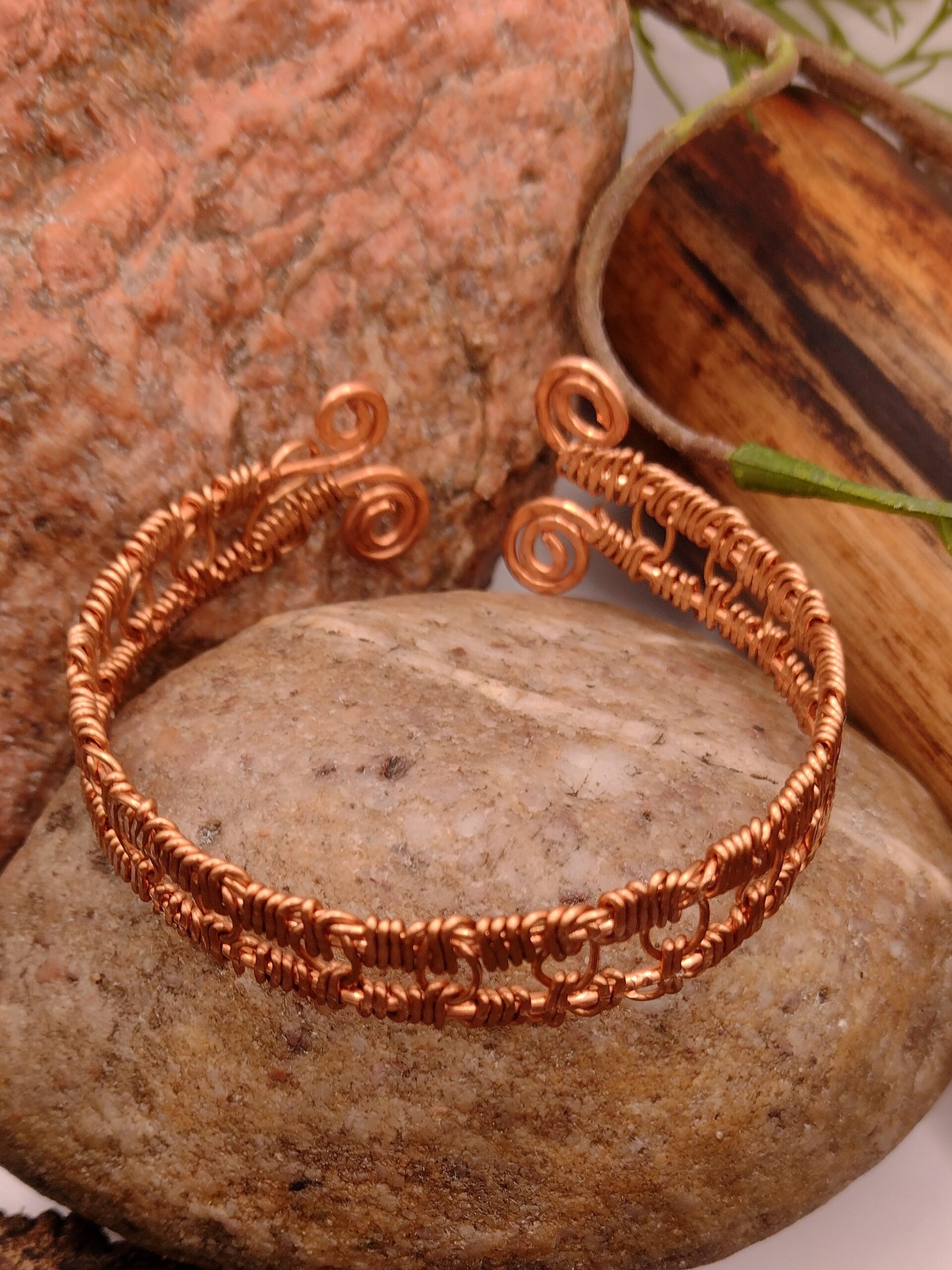 Bransoletka „Spirala Ciszy” z czystej miedzi, ręcznie wykonana, z symetrycznym splotem i spiralnymi zakończeniami, minimalistyczny design.