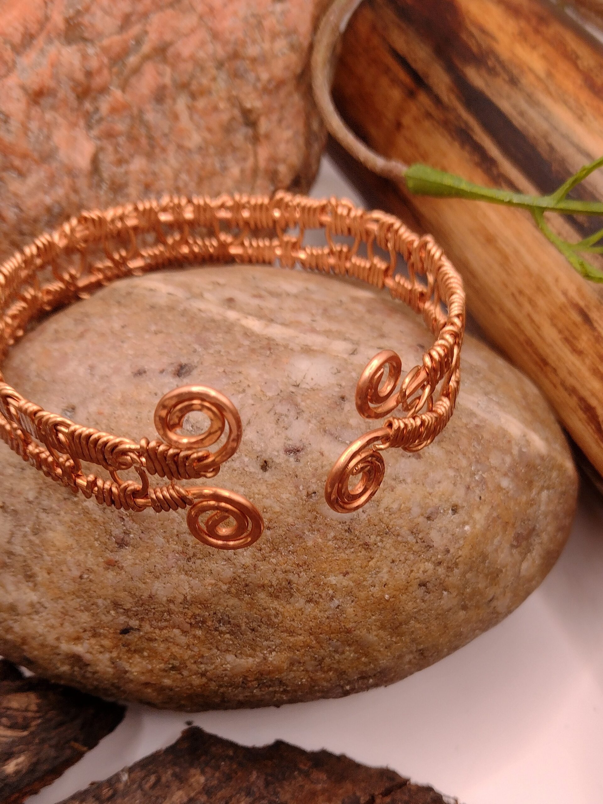 Bransoletka „Spirala Ciszy” z czystej miedzi, ręcznie wykonana, z symetrycznym splotem i spiralnymi zakończeniami, minimalistyczny design.