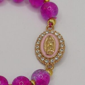 Bransoletka-różaniec na gumce z amarantowo-fioletowych szklanych koralików i złotych przekładek, z medalikiem Matki Boskiej oraz zawieszką z krzyżem.