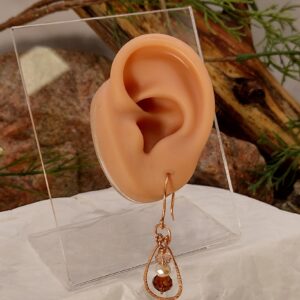 Kolczyki z miedzianą ramą i fasetowanymi koralikami w ciepłych odcieniach kremu i brązu.