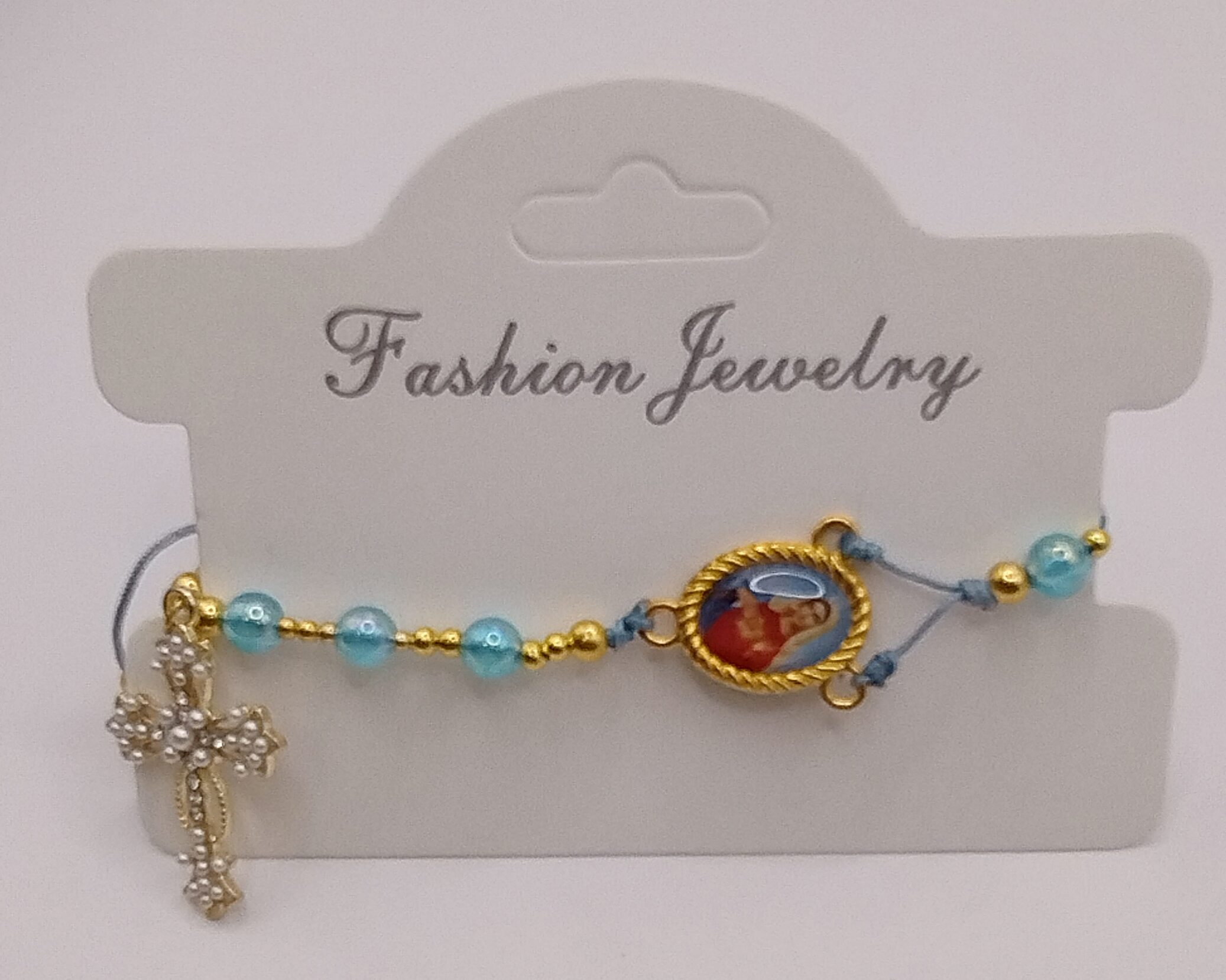 Ręcznie wykonana bransoletka religijna z turkusowych koralików i złotych przekładek, z ozdobnym krzyżykiem oraz medalikiem Matki Boskiej na regulowanym sznurku.
