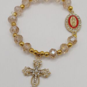 Bransoletka‑różaniec z białych fasetowanych koralików na gumce, z ozdobnym krzyżykiem i medalikiem Matki Boskie